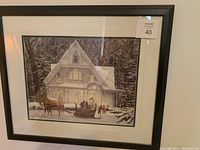 Framed print depicting a winter scene with horse-drawn sleigh outside a house welcoming family.