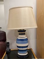 Full view of MCM style lamp showing the ceramic striped base and beige fabric lampshade, measuring approximately 29 inches tall.