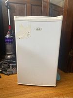 Front view of white Master Chef bar fridge with logo and label residue on door.