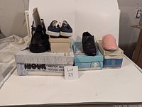 Photo of the 5 shoes and their original boxes in varying colors and styles.