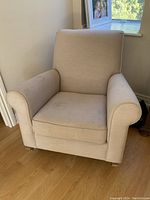 Photo of beige Pottery Barn rocking chair (glider) showing slight staining on upholstery and overall condition.