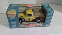 Diecast 1940 Ford pickup truck coin bank in original packaging shown from front angle.