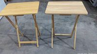 Two wood folding TV trays side by side showing top surface and frame