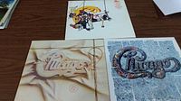 Photo showing the 3 Chicago vinyl album covers together on a wooden surface