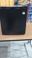 Closed front view of black Igloo mini fridge with logo on door.