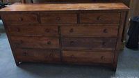 Front view of medium brown wood dresser with nine drawers