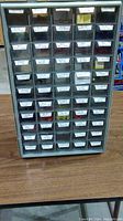 Front view of organizer showing multiple drawers with labels like Red Marrettes, Red Half Disc, Blue Bullet, Metal Stamps, and various sizes of wire connectors.