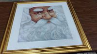 Full view of framed Santa Claus print with gold decorative frame and subtle scuffs visible.