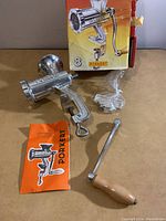 Metal Porkert manual meat grinder with clamp mount, wooden handle, instruction manual and original box.