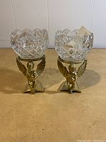 Pair of Royal Irish Crystal votive holders on angel-shaped brass stands on table