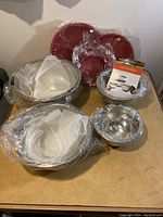 Complete 8-piece set showing four stainless steel bowls with four corresponding red lids, all wrapped in plastic.