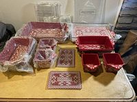 Full set displayed showing multiple sizes of ovenware dishes, trays and plates wrapped with protective bubble wrap and laid out on table