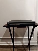 Front angle view of black Cisco 1841 Series router on a small wooden table with light background.