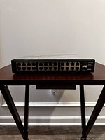 Front view of the Cisco SR2024C switch showing 24 Ethernet ports and status LEDs in a horizontal layout.