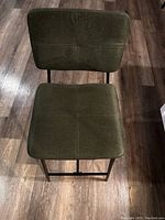 Top view of the army green upholstered stool seat and backrest showing square stitched pattern.