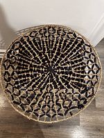 Top view of the circular woven woven wall or table decor showing blue and brown pattern.