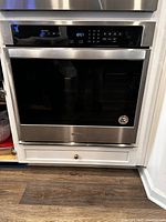 Front view of Whirlpool single wall oven installed under countertop showing stainless steel finish and control panel.