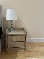 Bedside table closed with lamp on top showing front view