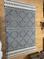 Top-down image of the full rug showing navy blue and white geometric diamond lattice pattern with patterned borders.