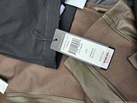 Close-up photo of two pairs of pants with leather panel accents and original tags visible indicating brand BCBG Max Azria, size Large