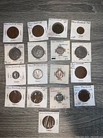 Full collection of 14 New Zealand coins in cardboard sleeves with various condition notes and values marked on sleeves.