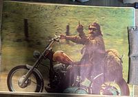 Full view of the 1970s Easy Rider poster showing Dennis Hopper on a motorcycle with his middle finger raised, highlighting the overall image and condition.
