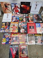 Photo capturing full spread of Michael Jordan memorabilia with books, magazines, and calendar arranged on the ground