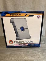 Photo of the sealed box of the Torque Planet Audio amplifier TRQ2.600 showing front branding, model, and power details