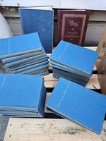 Photo showing multiple blue hardcover volumes and one larger maroon volume of William Shakespeare works.