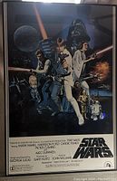 Front view of framed Star Wars movie poster showing full color characters and credits.