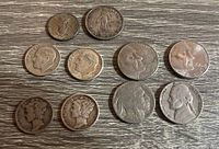 Top view of multiple US coins including Jefferson nickels, Lincoln pennies, Liberty seated dime, Buffalo nickel, and Mercury dimes. Coins show wear and patina.