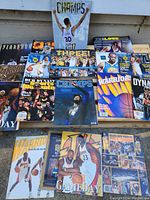 Photo showing a spread of about 15 basketball magazines focusing on NBA Golden State Warriors, including championship and yearbook editions with colorful covers featuring players and team graphics.