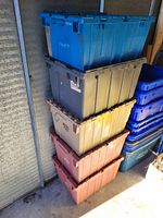 Stack of five plastic foldable storage totes in various colors in a storage area.