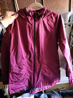 Front view of the burgundy Far West jacket, showing hood, sleeves, and full front zipper.