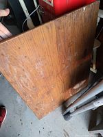 Photo showing the top surface of the wooden foldable table, which has scratches and wear marks.