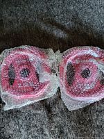 Two pink 2.5 lbs BodyRock weights wrapped in bubble wrap, side by side.