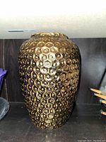 Photo of large decorative vase with honeycomb texture and gold finish