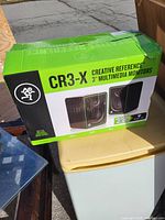 Closed box showing Mackie CR3-X Creative Reference speakers in green and black packaging.