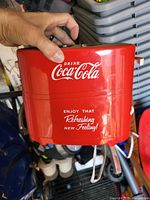 Red Coca-Cola toaster side view showing Coca-Cola logo and slogan on red metal body.