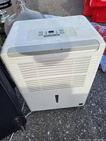 Front view of white dehumidifier showing vented front and water level indicator.