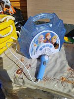 Frozen kids karaoke microphone and player toy showing front image with characters Elsa, Anna, Kristoff, and Olaf, microphone attached by cord.