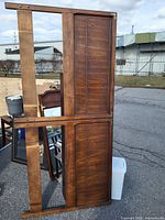 Full view of dark stained wooden king size headboard with vertical slatted panels and frame visible.