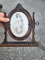 Photo of the ornate wooden oval picture frame with a built-in stand showing its detailed carvings and vintage style