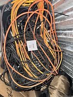 Close-up photo of tangled miscellaneous electrical cords in black, orange, and yellow colors.