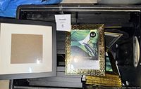 Photo showing gold-tone hammered metal 5x7 picture frames alongside larger black frames with white matting.
