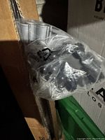 Close-up view of part of the room dividers in plastic packaging with parts of cardboard box and background storage visible.