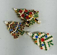 Front view of three Christmas-themed brooches showcasing colorful rhinestone designs.