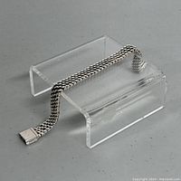 Bracelet draped on acrylic stand showing mesh link design and box clasp
