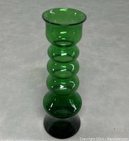 Front view of the green glass vase showing bubbled shape and flared top rim