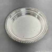 Top view of 5.75" sterling silver bowl with rope-twist border, smooth interior with minor spots
